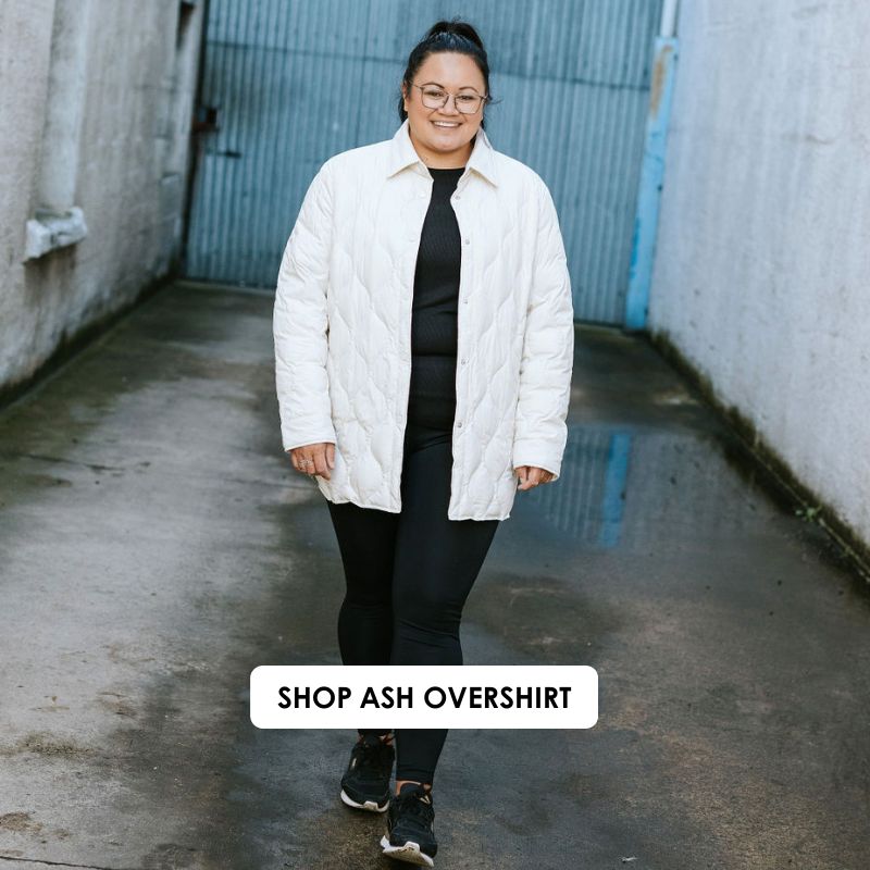 Person wearing a white quilted jacket in an alleyway with 'Shop Ash Overshirt' text.