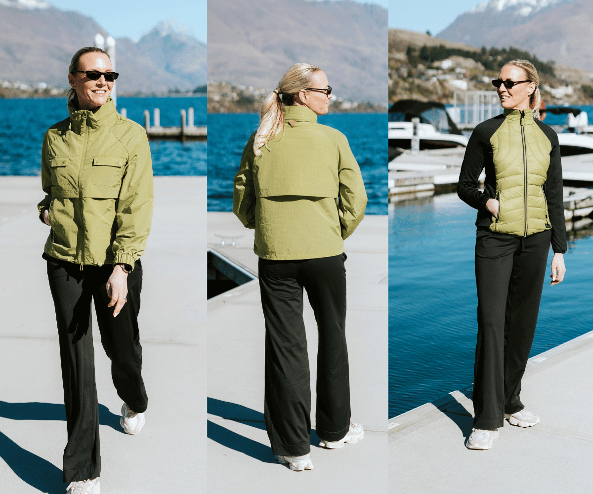 Woman wearing Moke olive green rain jacket and black puffer vest by a lake.