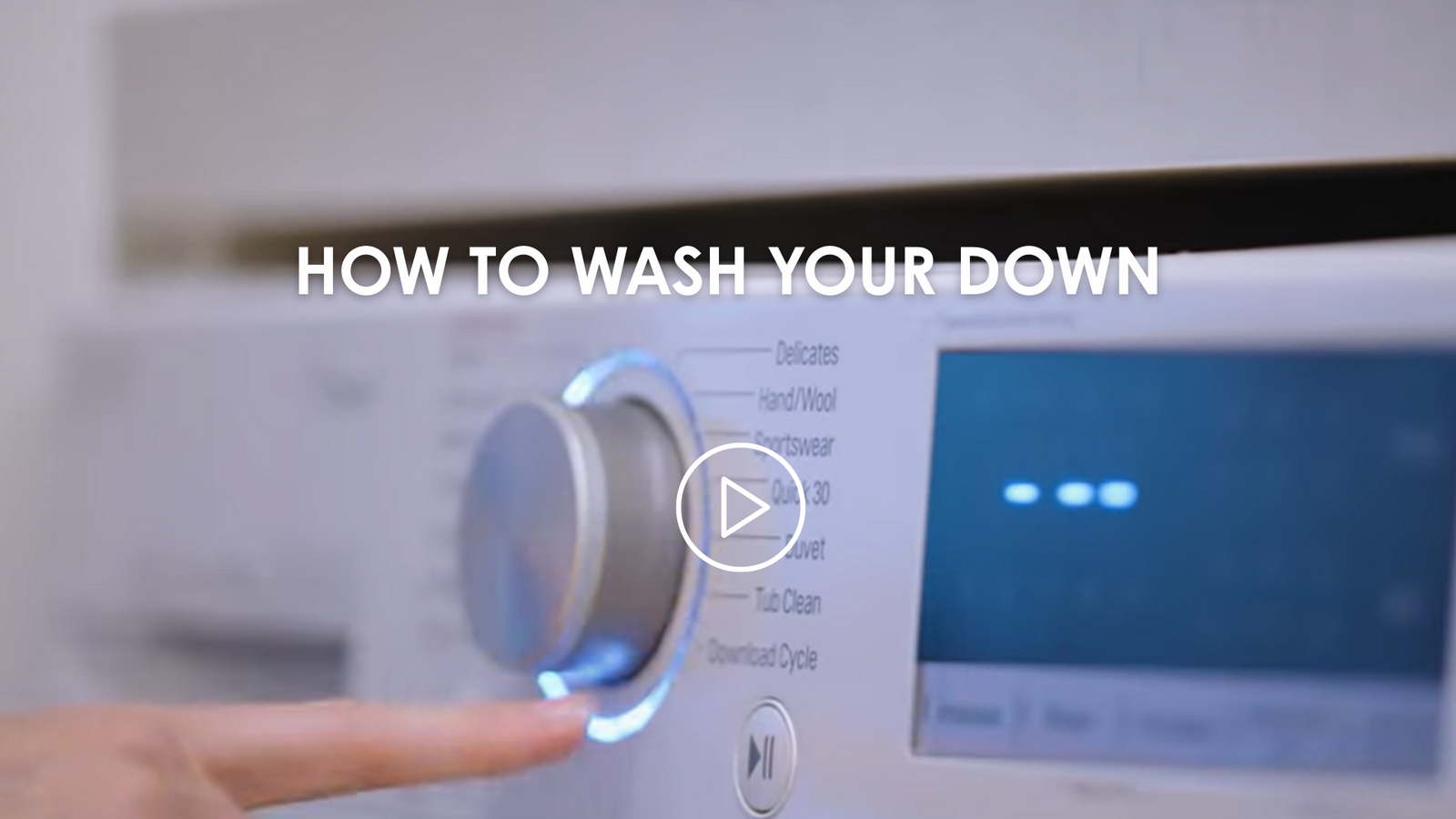 Hand pressing a button on a washing machine with text 'How to Wash Your Down'.