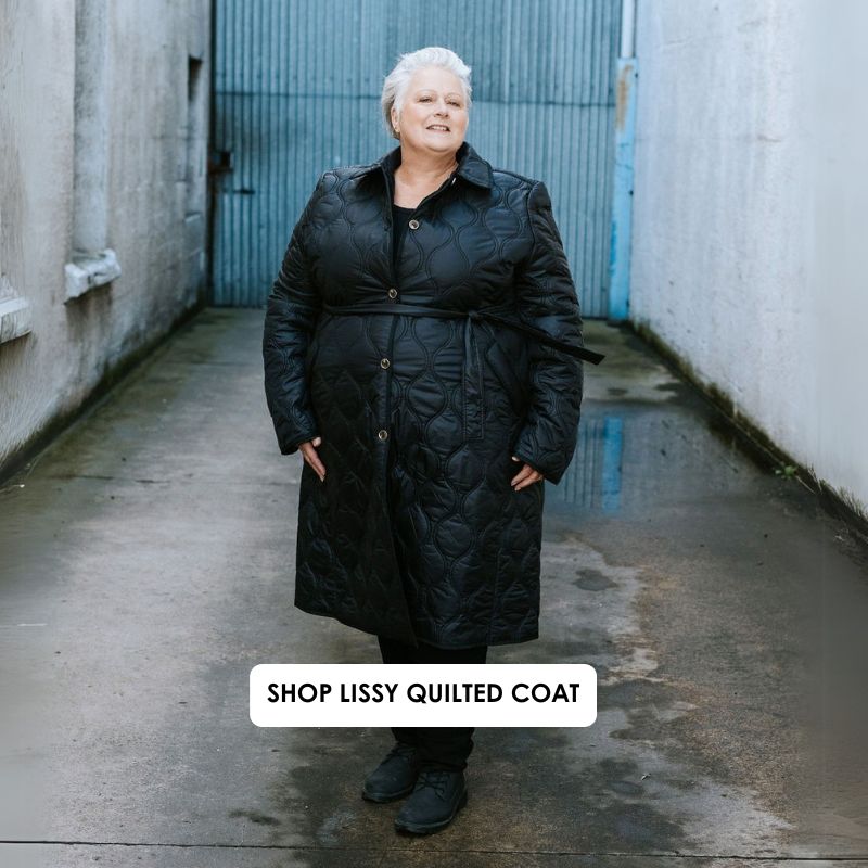 Person wearing a black quilted coat standing in an alleyway with text overlay.