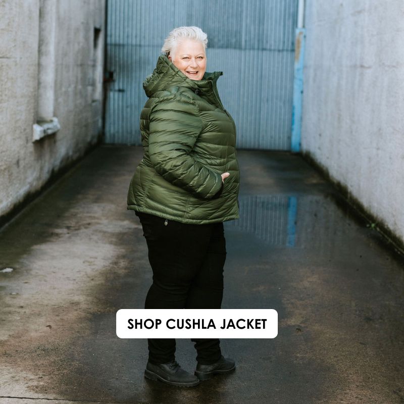 Person wearing a green puffer jacket standing in an alleyway with text 'Shop Cushla Jacket'.