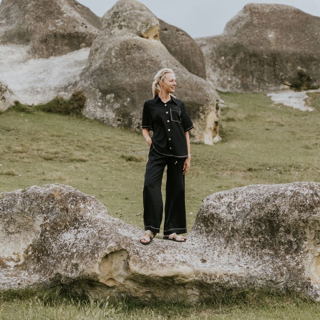 Person standing on a large rock formation in a natural landscape